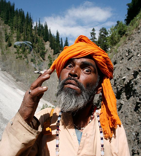 A sadhu smokes while on his way to the cave shrine