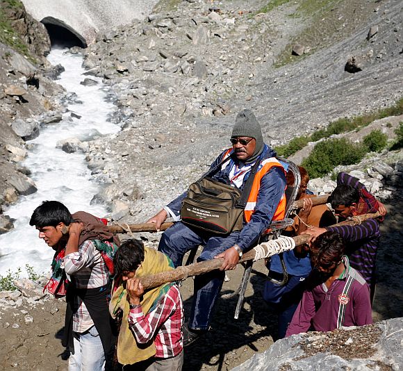 Porters carrying a pilgrim to the cave shrine