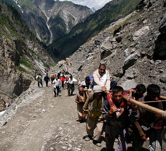 Porters carrying pilgrims to the cave shrine