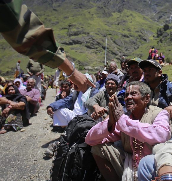 A survivor pleads with a soldier to allow him to board an army helicopter, during rescue operations at Badrinath