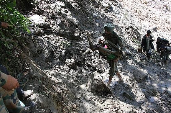 A soldier rescues an old woman in Uttarakhand