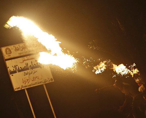 A protester opposing Egyptian President Mohamed Mursi throws Molotov cocktails at the national headquarters of the Muslim Brotherhood in Cairo's Moqattam district