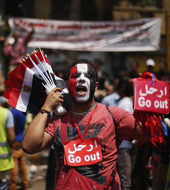 A vendor sells flags and anti-Mursi signs during protest demanding that Egyptian President Mohamed Mursi resign at Tahrir Square in Cairo