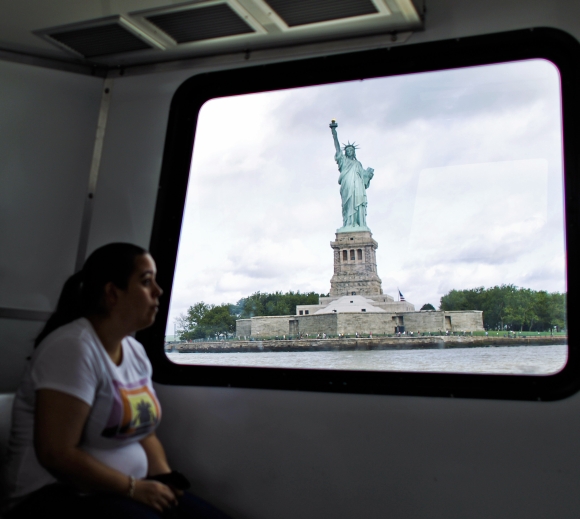A woman rides a ferry to visit the Statue of Liberty and Liberty Island