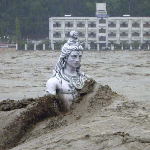  The statue of a Lord Shiva is submerged by flood waters of the river Ganges in Uttarakhand