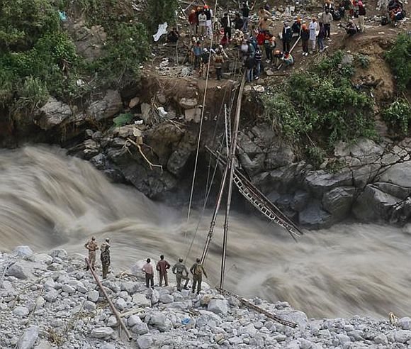 Soldiers work to install a temporary footbridge over a river to rescue the stranded