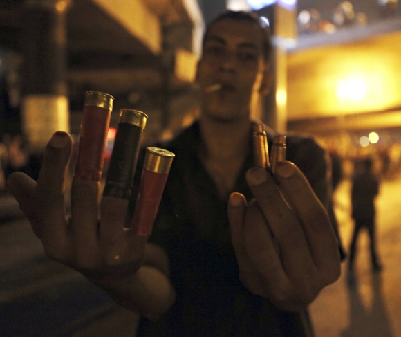 An anti-Morsi protester shows spent shell casings and rubber bullets during clashes with members of the Muslim Brotherhood and supporters of ousted the Egyptian president near Tahrir Square