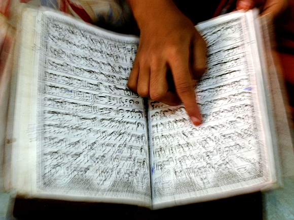 A Muslim girl reads the Koran inside a Madrasa in Mumbai