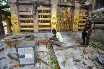 Security personnel inspect the site of an explosion inside the Mahabodhi temple complex at Bodh Gaya.