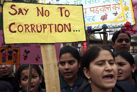 School students shout slogans during a protest against a corruption case in Jammu.
