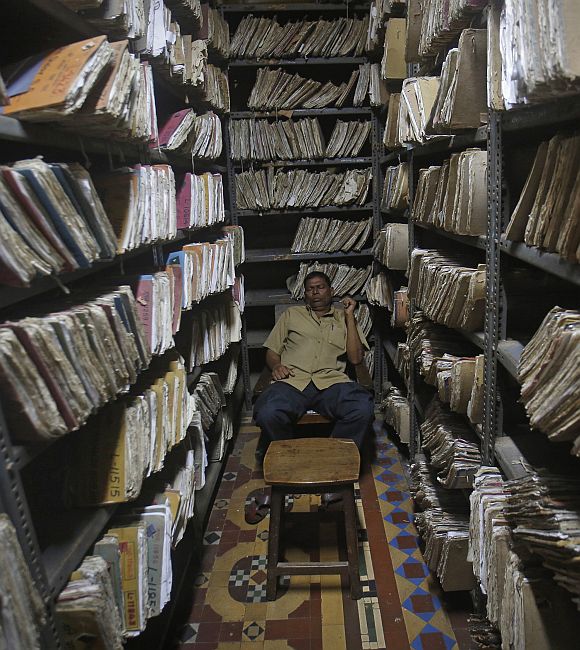 An employee sleeps in the record section room of the Central Telegraph Office in Mumbai