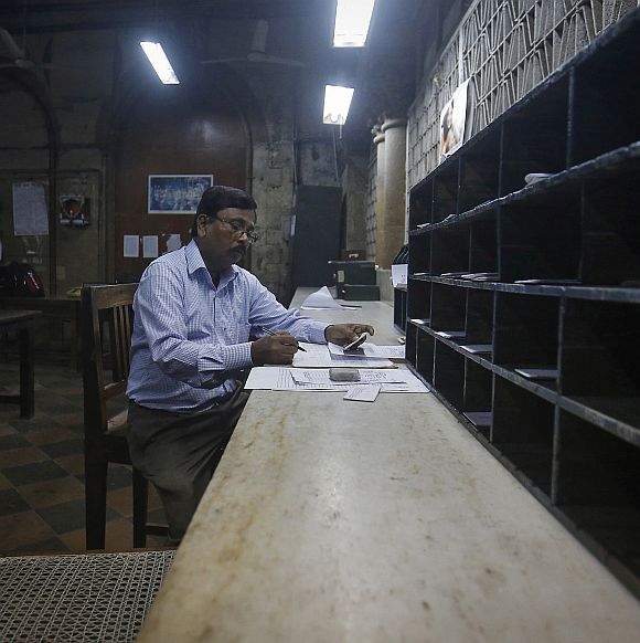 An employee writes down addresses before dispatching telegrams inside the delivery section room of the Central Telegraph Office in Mumbai