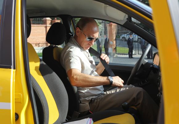 Russia's Prime Minister Vladimir Putin fastens his seat belt as he prepares to drive a  Russian-made Lada Kalina car in the city of Khabarovsk.