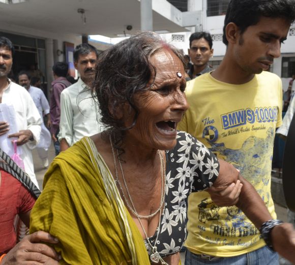 A woman cries after her grandson, who consumed a meal at school on Tuesday, died at a hospital in Patna