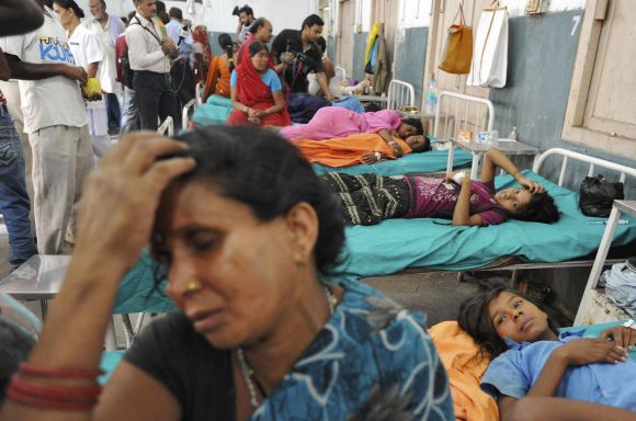 Asha Devi sits next to her sick daughter Savita, at a hospital in Patna