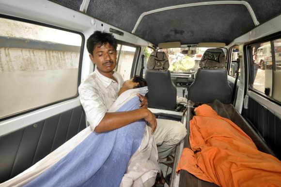 A man holds his sick child on thier way to the hospital in Patna