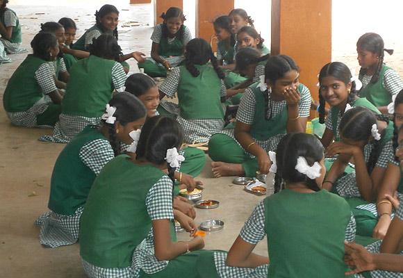 Girls eating by themselves in the high school corridor