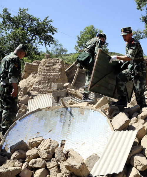 Paramilitary policemen search for victims amongst collapsed houses after a 6.6 magnitude earthquake hit Minxian county, Dingxi, Gansu province