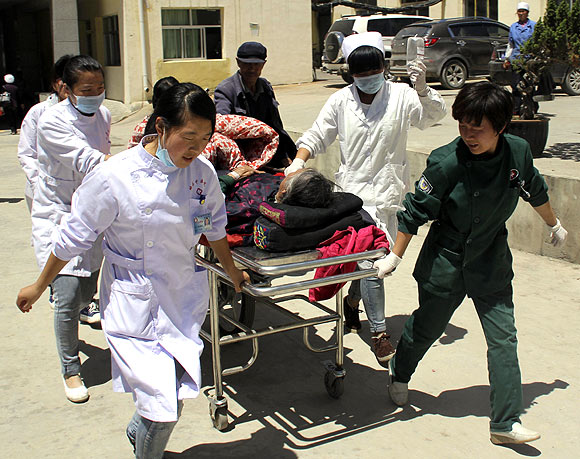 An injured woman lies on a stretcher as she is pushed into a hospital
