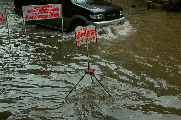 A car wades through a waterlogged road near the Hindmata chowk  chowjk