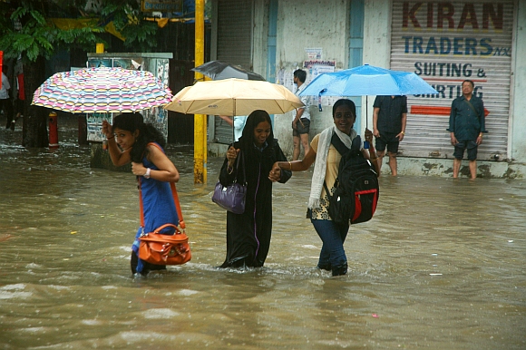 Commuters wade through knee-deep water at Hindmata chowk