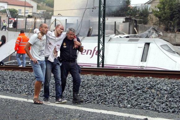 Rescue workers help a victim of a train crash near Santiago de Compostela