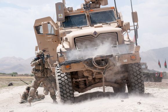 A US Army paratrooper with the 82nd Airborne Division's 1st Brigade Combat Team fires his M4 carbine at insurgents during a firefight in Ghazni Province, Afghanistan