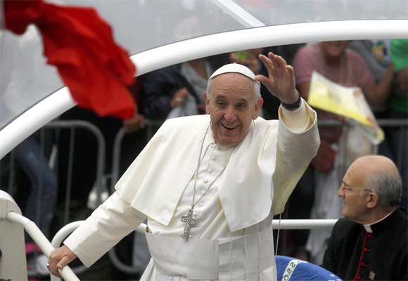 Pope Francis greets Catholic faithful as he arrives for his final mass on Copacabana Beach in Rio de Janeiro.