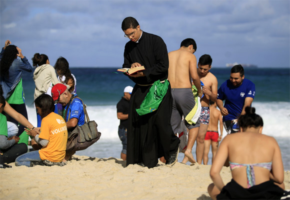 A priest reads the Bible as he awaits Pope Francis's arrival.