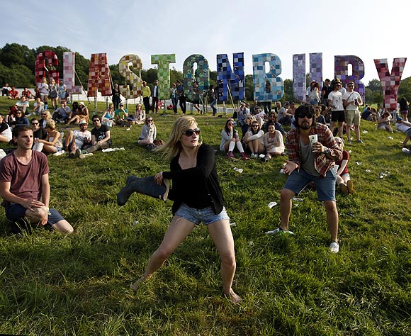 Festival goers play baseball, batting a beer can with a wellington boot, on the first day of Glastonbury music festival at Worthy Farm in Somerset