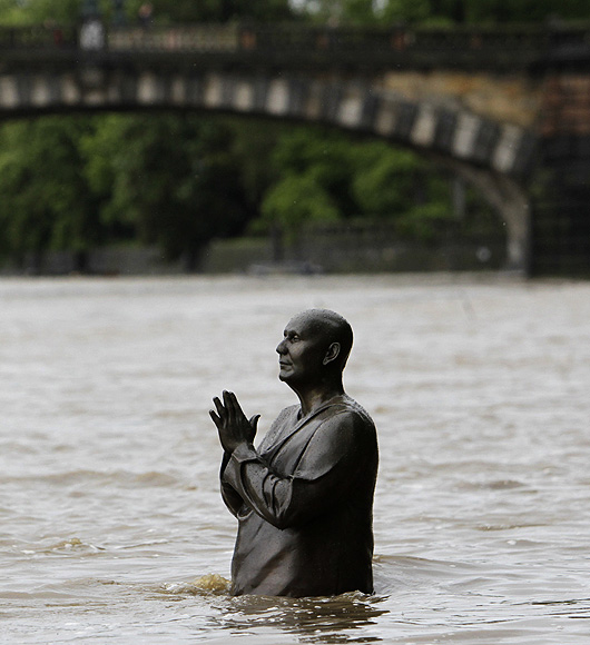 The statue of world harmony leader Sri Chinmoy is partially submerged in water from the rising Vltava river in Prague, Czech Republic.