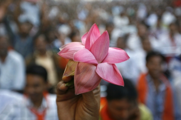 A BJP supporter holds his party's lotus symbol during a ceremony