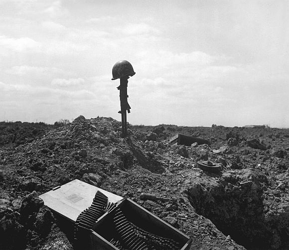 A Coast Guard Combat Photographer came upon this monument to a dead American soldier somewhere on the shell-blasted shore of Normandy, in this June 1944 file photo