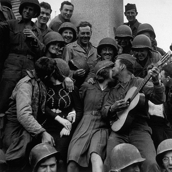 A happy crowd of American soldiers receive a warm welcome from the inhabitants of Cherbourg, after its liberation
