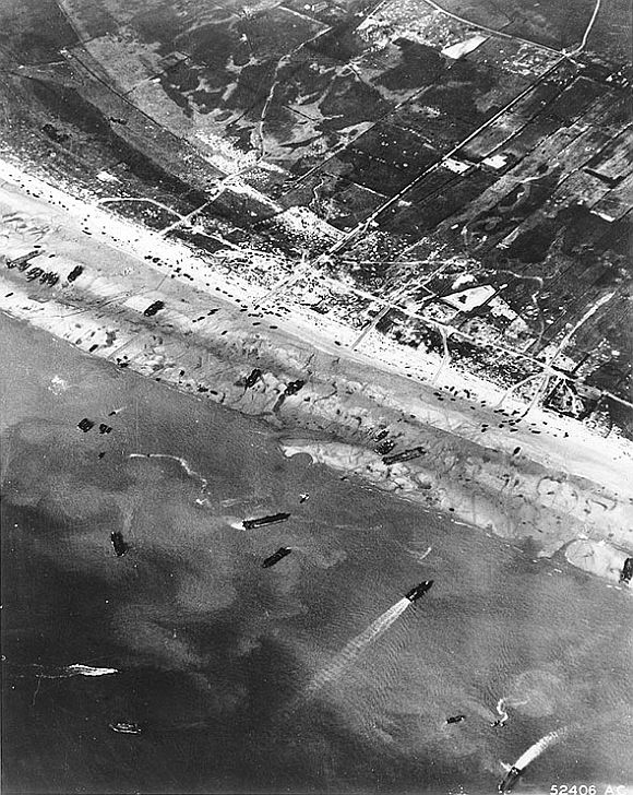 D-Day beach traffic, photographed from a Ninth Air Force bomber on June 6, 1944. Note the vehicle lanes leading away from the landing areas, and landing craft left aground by the tide.