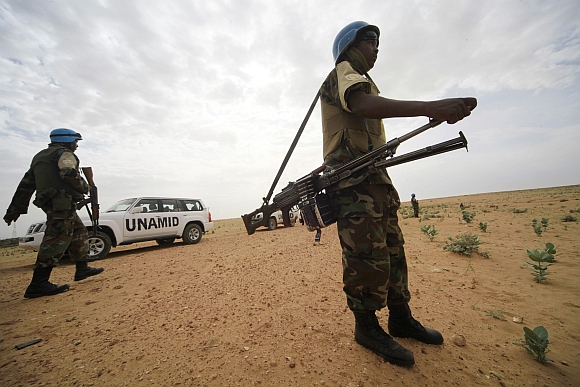 United Nations Hybrid Operation in Darfur peacekeepers stand guard as a delegation of ambassadors of European Union to Sudan visits a women development program centre funded by World Food Programme at Shagra village in North Darfur