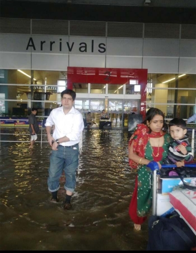 Stranded passengers try to wade through the water-logged airport