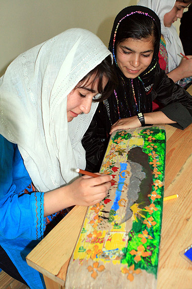 A student paints her skateboard at the centre in Kabul
