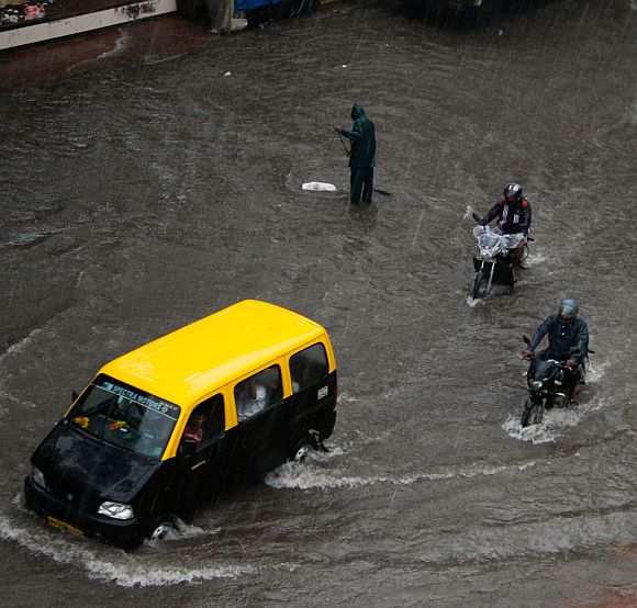 A taxi plies on a flooded street at Sion