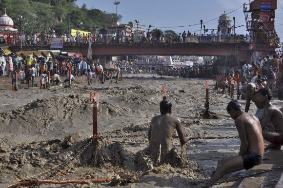 A Hindu devotee tries to take a holy dip in the flooded waters of river Ganges in the northern Indian town of Haridwar