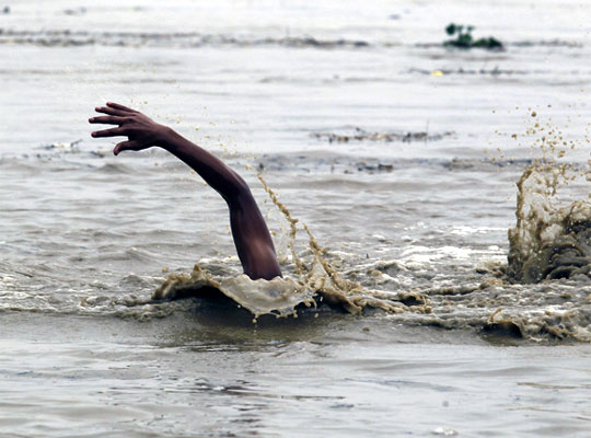 A man swims in the flooded waters of river Yamuna
