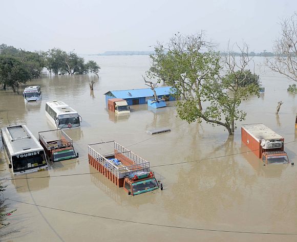 Vehicles are submerged in the rising waters of the river 