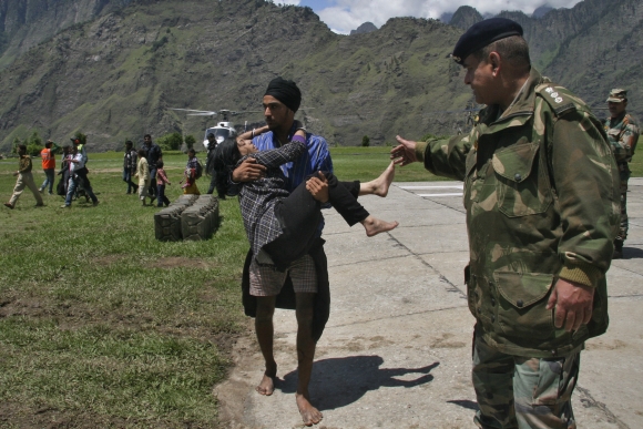 A man carries a flood affected victim after they were rescued by the Indian army in Uttarakhand
