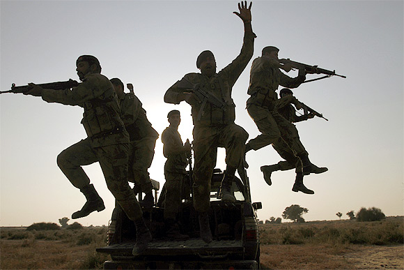Pakistan Army soldiers leap from a vehicle during winter military exercises