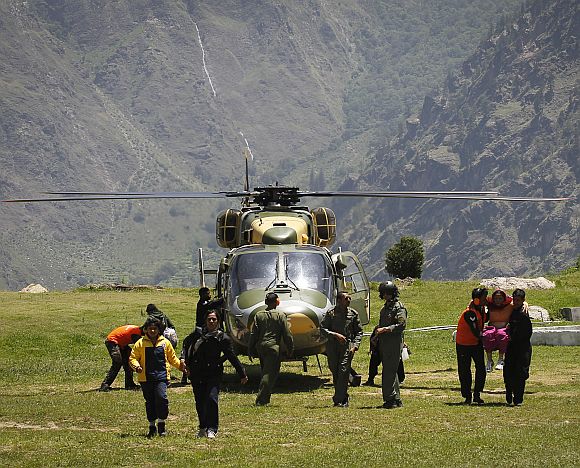 Survivors get out from an army helicopter during a rescue operation at Joshimath
