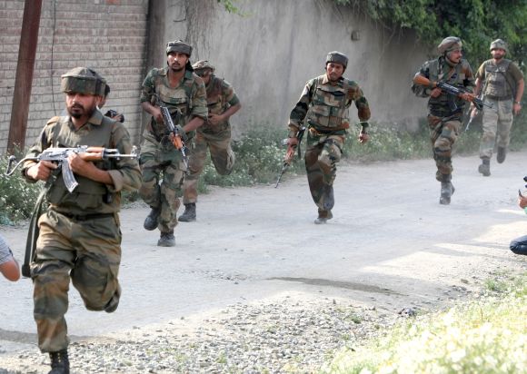 Army personnel taking positions after a militant strike on a convoy outside Srinagar on Monday