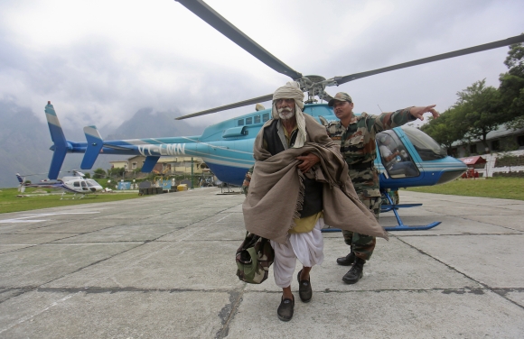 A man is guided by a soldier during a rescue operation at Joshimath
