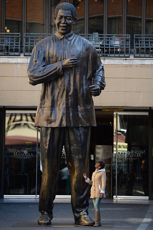 Members of the public visit the Nelson Mandela statue in Sandton in Johannesburg