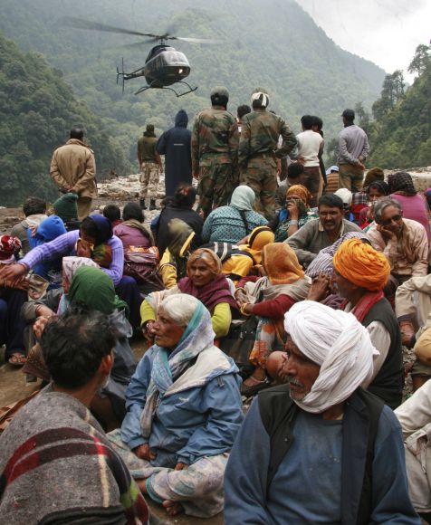 Stranded people wait for their turn to be rescued by a helicopter after heavy rains in the Himalayan state of Uttarakhand