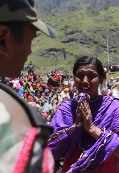 A survivor pleads with a soldier to allow her mother to board an army helicopter during rescue operations at flood-ravaged Badrinath, Uttarakhand.